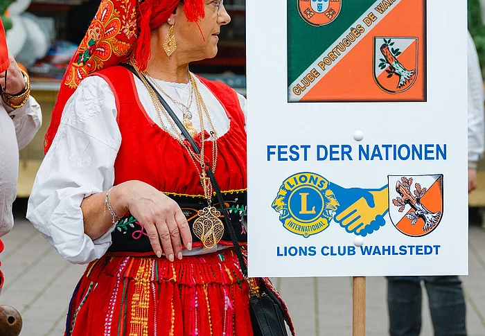 Frau in potugiesischer Tracht mit Schild Fest der Nationen
