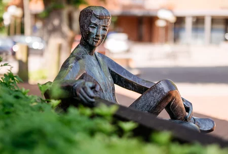 Figur auf Bank sitzend