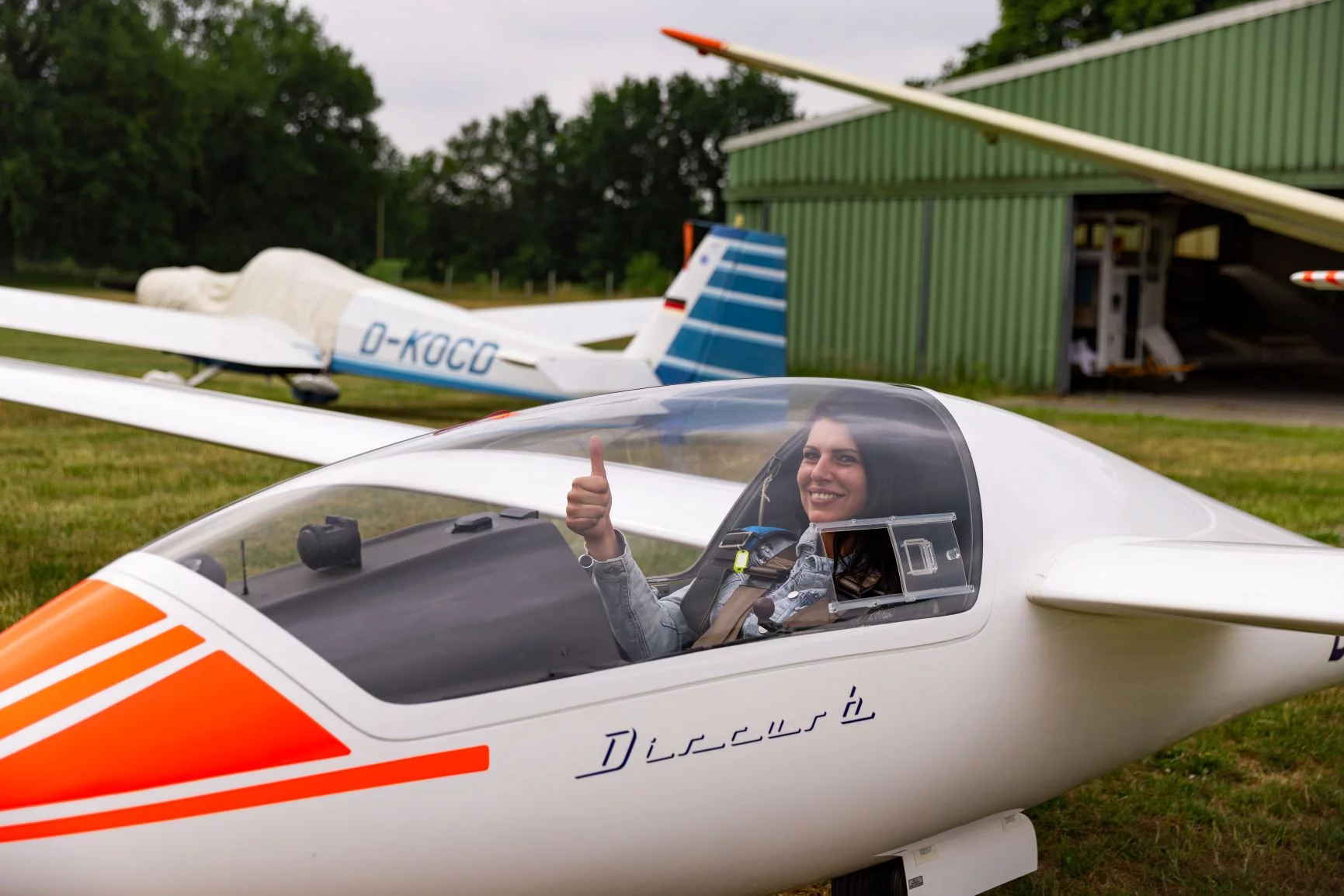 Frau in Cockpit zeigt Daumen hoch/Start frei
