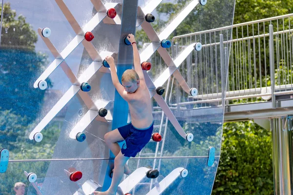 Junge an Wasser-Kletterwand