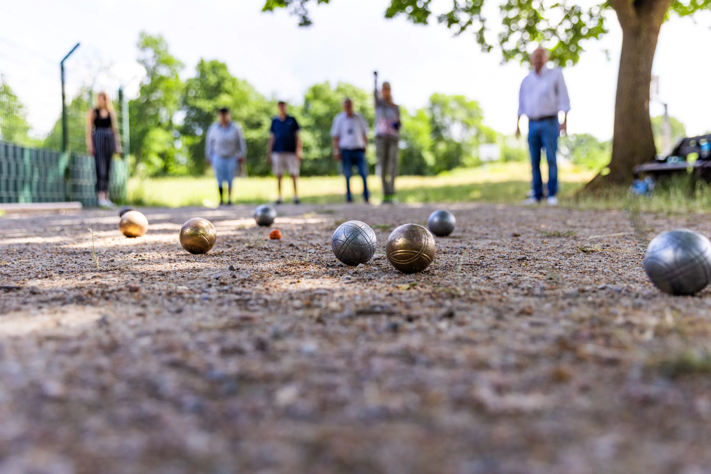 Gruppe Boulespieler, Kugeln im Vordergrund